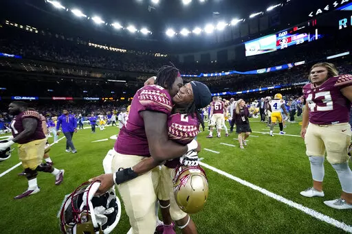 CORRECTS TO BLOCKED EXTRA POINT INSTEAD OF A BLOCKED FIELD GOAL - Florida State running back Treshaun Ward (8) celebrates with offensive lineman Darius Washington (76) after defeating LSU on a blocked extra point with no time remaining, in an NCAA college football game in New Orleans, Sunday, Sept. 4, 2022. Florida State won 24-23. (AP Photo/Gerald Herbert)