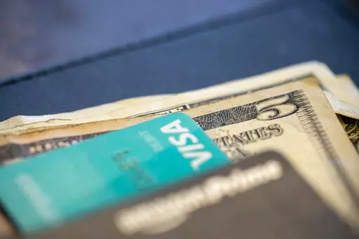 In this Aug. 11, 2019 file photo, U.S. currency and credit cards sit on a table at a restaurant in New Orleans. With inflation at 7.1% in November, it’s not surprising that savings aren’t going as far as they used to. Part-time gigs like tutoring, pet sitting or helping with tax prep allow retirees to work a few hours at a time, and the extra income can make a big differenc(AP Photo/Jenny Kane, File)