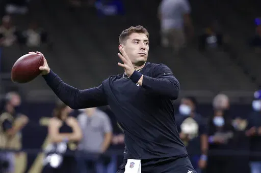 FILE - New Orleans Saints quarterback Ian Book warms up before the team;s NFL football game against the New York Giants in New Orleans on Oct. 3, 2021. The rookie out of Notre Dame, selected by the Saints in the fourth round of the 2021 draft, is expected to take his first regular season NFL snaps on Monday night against Miami. A COVID-19 outbreak affecting more than a dozen Saints players including quarterbacks Taysom Hill and Trevor Siemian left the Saints little choice but to elevate Book to 