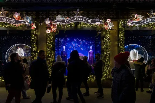 Shoppers and pedestrians walk past a window display at Saks Fifth Avenue in New York, Dec. 14, 2023. (AP Photo/Peter K. Afriyie, File)