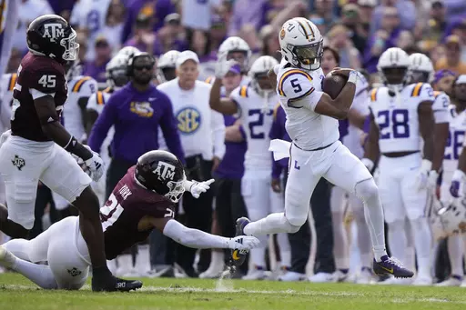 LSU quarterback Jayden Daniels (5) carries past Texas A&M linebacker Taurean York (21) in the first half of an NCAA college football game in Baton Rouge, La., Saturday, Nov. 25, 2023. (AP Photo/Gerald Herbert)