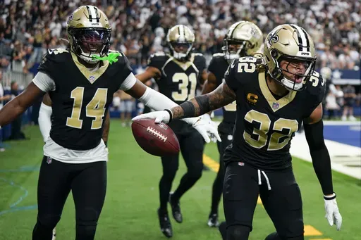 New Orleans Saints safety Tyrann Mathieu (32) reacts with teammates, including Kool-Aid McKinstry (14) and Jordan Howden (31) after intercepting a pass by Dallas Cowboys quarterback Dak Prescott during the second half of an NFL football game, Sunday, Sept. 15, 2024, in Arlington, Texas. (AP Photo/Jeffrey McWhorter)