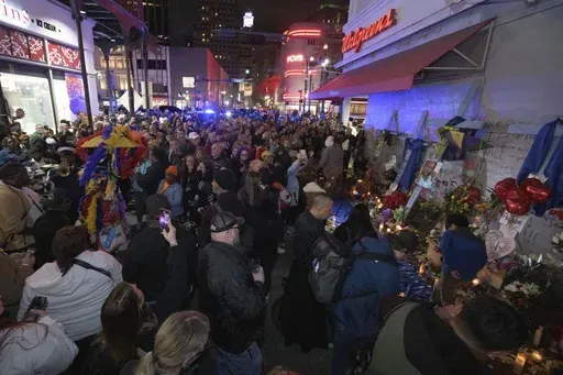 People crowd Bourbon Street near the intersection of Canal Street in New Orleans, Saturday, Jan. 4, 2025, as they memorialize the victims of the New Year's Day deadly truck attack and shooting. (AP Photo/Matthew Hinton)