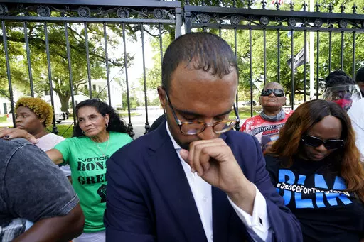 Mona Hardin, background left in green, mother of Ronald Greene, prays outside the gates of the governor's mansion in Baton Rouge, La., on May 27, 2021, while protesting her son's death. Greene died in the custody of Louisiana State Police in 2019. Ron Haley, attorney for the Greene family, foreground, has been hired by the family of Alonzo Bagley, a man fatally shot by police in Shreveport, La., on Feb. 3, 2023. The head of Louisiana State Police is calling for patience as detectives look into t