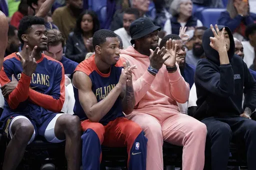 New Orleans Pelicans center Yves Missi, left, forward Jamal Cain, forward Zion Williamson and guard Dejounte Murray applaud for their teammates during the second half of an NBA basketball game against the Philadelphia 76ers in New Orleans, Monday, March 24, 2025. (AP Photo/Matthew Hinton)