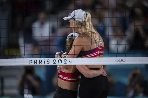 United States' Taryn Kloth and Kristen Nuss celebrate victory in the women's pool B beach volleyball match between USA and Canada at Eiffel Tower Stadium at the 2024 Summer Olympics, Saturday, July 27, 2024, in Paris, France. (AP Photo/Louise Delmotte)