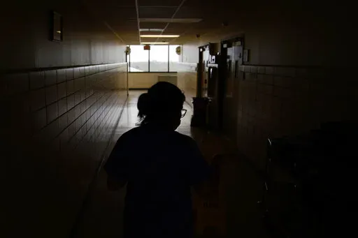 A chief nursing officer walks down a hallway in the recently reopened emergency room at a hospital  in Houma, La., on Friday, Sept. 3, 2021. Patients worried about getting smacked with an unexpected bill after emergency care gained a layer of protection in January 2022 from a new federal law. The No Surprises Act prevents doctors or hospitals in many situations from billing insured patients higher rates because the care providers are not in their insurer’s coverage network. (AP Photo/John Loch