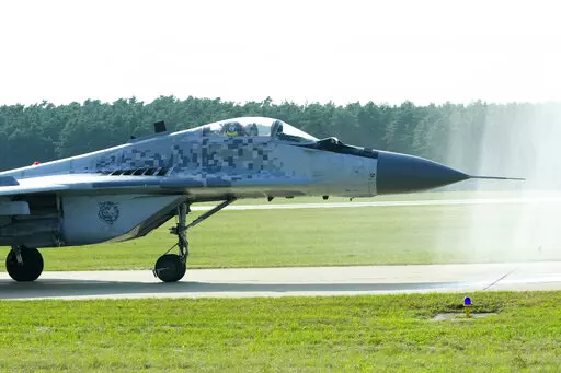 Slovak Air Force MiG-29 goes through a water gate during an airshow in Malacky, Slovakia, Saturday, Aug. 27, 2022. Former Soviet satellite Slovakia has been a NATO member since 2004, but the reality of belonging to the world’s biggest military alliance really kicked in after Russia’s invasion of Ukraine a year ago. The small central European country now hosts thousands of NATO troops while allied aircraft patrol its skies. (AP Photo/Petr David Josek,File)