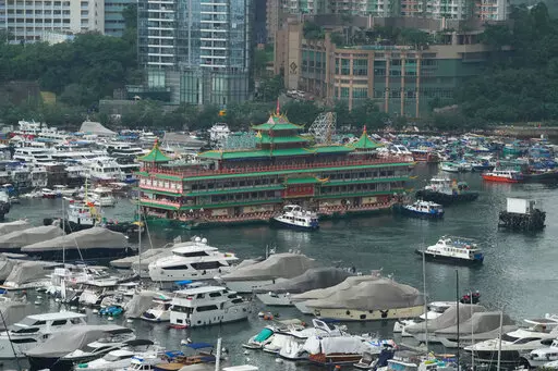 Hong Kong's iconic Jumbo Floating Restaurant is towed away in Hong Kong, Tuesday, June 14, 2022. Hong Kong's iconic restaurant on Tuesday departed the city, after its parent company failed to find a new owner and lacked funds to maintain the establishment amid months of COVID-19 restrictions. (AP Photo/Kin Cheung)