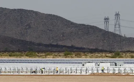 Workers continue to build rows of solar panels at a Mesquite Solar 1 facility under construction in Arlington, Ariz., Sept. 30, 2011. One of President Joe Biden's signature laws aimed to invigorate renewable energy manufacturing in the U.S. It will also helped a solar panel company reap billions of dollars. Arizona-based First Solar is one of the biggest early winners from the Democrats' Inflation Reduction Act, offering a textbook case of how the inside influence game works in Washington.(AP Ph