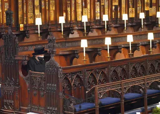 Britain's Queen Elizabeth II sits alone in St. George's Chapel during the funeral of Prince Philip, the man who had been by her side for 73 years, at Windsor Castle, Windsor, England, Saturday April 17, 2021. Boris Johnson's former communications chief has apologized "unreservedly" on Friday for a lockdown-breaching party in Downing Street last year. The Daily Telegraph said Downing Street staff drank, danced and socialized on April 16 last year, the night before the funeral of Prince Philip. Th