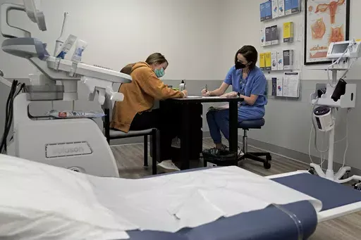 Dr. Elizabeth Brett Daily talks with patient Haley Ruark about the medical abortion process at a Planned Parenthood clinic, Oct. 12, 2022, in Kansas City, Kan. Comprehensive Health of Planned Parenthood Great Plains announced Tuesday, May 14, 2024, that Pittsburg, Kansas, will be home to a new facility providing abortion procedures and pills, as well as pregnancy services, contraception and testing and treatment for sexually transmitted diseases. (AP Photo/Charlie Riedel, File)