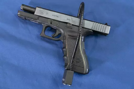 Displayed is a Glock 17 pistol fitted a with a cable style gun lock in Philadelphia, Wednesday, May 10, 2023. A federal judge in Virginia has ruled that a law banning licensed firearms dealers from selling handguns to young adults under 21 violates the Second Amendment and is unconstitutional. The ruling Wednesday, May 10, by U.S. District Court Judge Robert Payne in Richmond, if not overturned, would allow dealers to sell handguns to 18- to 20-year-olds. (AP Photo/Matt Rourke, File)