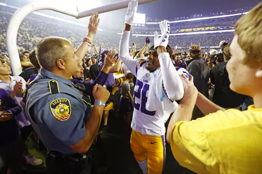 LSU cornerback Damarius McGhee (26) celebrates with fans who stormed the field after an NCAA college football game against Alabama in Baton Rouge, La., Saturday, Nov. 5, 2022. LSU won 32-31 in overtime. (AP Photo/Tyler Kaufman)