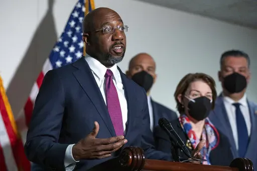 Sen. Raphael Warnock, D-Ga., speaks to reporters alongside Sen. Cory Booker, D-N.J., and Sen. Amy Klobuchar, D-Minn., and Sen. Alex Padilla, D-Calif., during a news conference at the Capitol in Washington, on Jan. 18, 2022. There's a shifting narrative on COVID-19 restrictions across the country among Democratic officials and candidates. They're increasingly supportive of easing mandates as they struggle to address voter frustration with the lingering pandemic. (AP Photo/Amanda Andrade-Rhoades, 