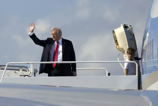 President Donald Trump, left, waves as he boards Air Force One with grandson Theodore, Ivanka Trump's son, at Palm Beach International Airport in West Palm Beach, Fla., Sunday, Feb. 9, 2025. (AP Photo/Ben Curtis)