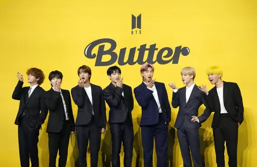 FILE- Members of South Korean K-pop band BTS, V, SUGA, JIN, Jung Kook, RM, Jimin, and j-hope from left to right, pose for photographers ahead of a press conference to introduce their new single "Butter" in Seoul, South Korea, Friday, May 21, 2021. Three members of the K-pop superstar group BTS have been infected with the coronavirus.  the Big Hit Entertainment agency says in a statement that RM and Jin were diagnosed with COVID-19 on Saturday evening. It earlier said another member, Suga, teste