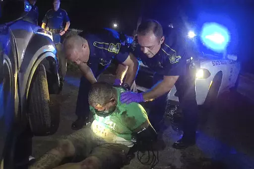 This image from the body camera video of Louisiana State Police Trooper Dakota DeMoss shows his colleagues, Kory York, center left, and Chris Hollingsworth, center right, holding up Ronald Greene before paramedics arrived on May 10, 2019, outside of Monroe, La. Louisiana lawmakers investigating the deadly 2019 arrest of Greene are preparing to hold Kevin Reeves, the former head of the state police, in contempt for refusing to turn over his journals after talks broke down Monday, May 2, 2022, in 