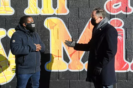 Second gentleman Doug Emhoff, the spouse of Vice President Kamala Harris, right, speaks with Christopher Bradshaw, executive director of Dreaming out Loud, a nonprofit organization focused on food security and economic opportunity, during a visit to Kelly Miller Middle School in Washington, on Jan. 28, 2021. (Nicholas Kamm/Pool via AP, File)