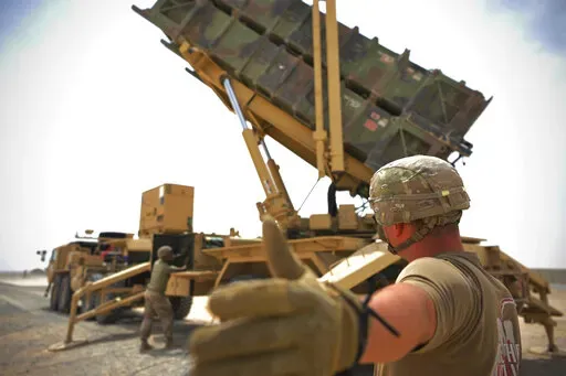 In this photo released by the U.S. Air Force, U.S. Army Spc. Scottlin Bartlett of the 5-52 Air Defense Artillery Battalion signals to a colleague while working near a Patriot missile battery at Al-Dhafra Air Base in Abu Dhabi, United Arab Emirates, May 5, 2021. The wars of the wider Middle East that long surrounded the United Arab Emirates now have encroached into daily life in this U.S.-allied nation, threatening to draw America further into a region inflamed by tensions with Iran. Al-Dhafra ha