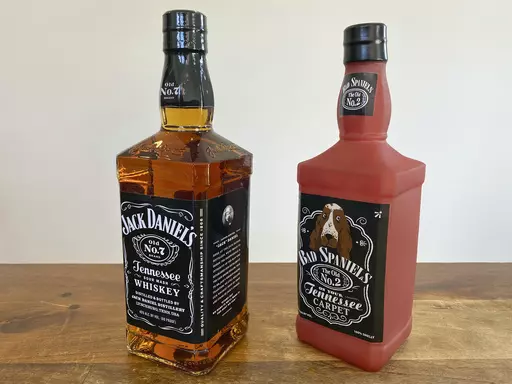 A bottle of Jack Daniel's Tennessee Whiskey is displayed next to a Bad Spaniels dog toy in Arlington, Va., Nov. 20, 2022. The Supreme Court is hearing a dispute, Wednesday, March 22, 2023 between Jack Daniel’s and the manufacturer of the squeaking dog toy that parodies the liquor’s bottle and label. The question for the court has to do with whether the toy makers infringed on Jack Daniel’s trademarks. Arizona-based VIP Products produces the Bad Spaniels toy. While the original bottle has t