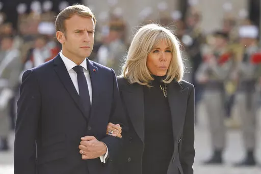 FILE. French President Emmanuel Macron and his wife Brigitte Macron attend a national memorial ceremony for Hubert Germain at the Hotel des Invalides, Friday Oct.15, 2021 in Paris. A group of "atypical journalists," on the autism spectrum, got France's 45-year-old president to talk about himself with unusual and illuminating candour in a televised interview this weekend. (Ludovic Marin, Pool Photo via AP)