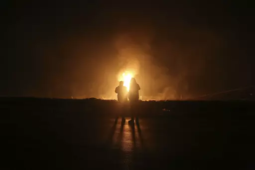 Two men look at flames after a natural gas pipeline explodes outside the city of Boroujen in the western Chaharmahal and Bakhtiari province, Iran, in early Wednesday, Feb. 14, 2024. Explosions struck a natural gas pipeline in Iran early Wednesday, with an official blaming the blasts on a "sabotage and terrorist action" in the country as tensions remain high in the Middle East amid Israel's war on Hamas in the Gaza Strip. (Reza Kamali Dehkordi/Fars News Agency via AP)