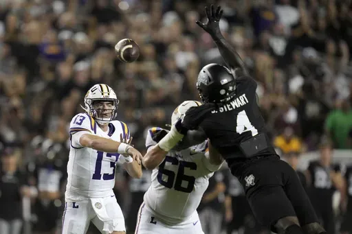 LSU quarterback Garrett Nussmeier (13) gets a pass by Texas A&M defensive lineman Shemar Stewart (4) for a first down catch during the first quarter of an NCAA college football game Saturday, Oct. 26, 2024, in College Station, Texas. (AP Photo/Sam Craft)