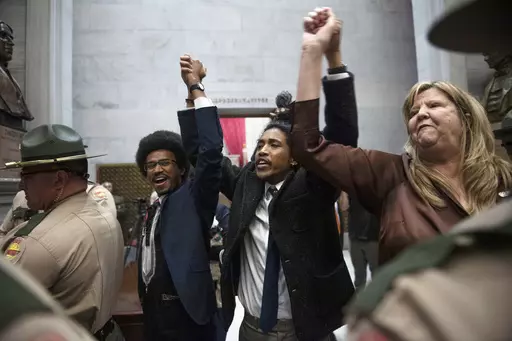 From left, Tennessee state Rep. Justin Pearson, state Rep. Justin Jones and state Rep. Gloria Johnson hold their hands up as they exit the House Chamber doors at Tennessee state Capitol Building in Nashville, Tenn., Monday, April 3, 2023. In Tennessee, three Democratic House members are facing expulsion for using a bullhorn in the House chamber to show support for pro-gun control protesters. In an increasingly polarized political atmosphere, experts say these kinds of harsh punishments for minor