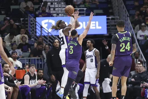 Sacramento Kings guard Keon Ellis (23) shoots a three-pointer over New Orleans Pelicans guard CJ McCollum (3) during the first half of an NBA basketball game in New Orleans, Wednesday, Feb. 12, 2025. (AP Photo/Peter Forest)