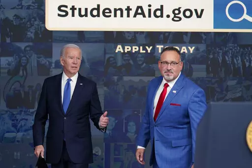 President Joe Biden answers questions with Education Secretary Miguel Cardona as they leave an event about the student debt relief portal beta test in the South Court Auditorium on the White House complex in Washington, Oct. 17, 2022. The Biden administration is no longer accepting applications for student loan forgiveness after a second federal court shut down the program. (AP Photo/Susan Walsh, File)