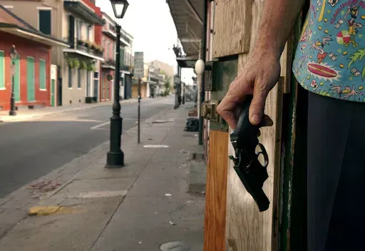 A New Orleans French Quarter resident holds a handgun as he keeps watch on his house on Bourbon Street, Sept. 12, 2005. As Louisiana prepares for a new law to go into effect that allows those 18 and older to carry a concealed handgun without a permit, a Republican-controlled committee pushed back against bills Wednesday, April 17, 2024, that seek to restrict where people can carry guns. (Jay Janner/Austin American-Statesman via AP, File)