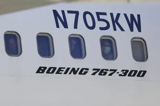 Venezuelan migrants deported from the United States peer through windows of an Eastern Airlines plane upon arriving at Simon Bolivar International Airport in Maiquetia, Venezuela, Sunday, March 30, 2025. (AP Photo/Cristian Hernandez)