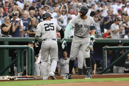 New York Yankees' Gleyber Torres (25) celebrates after his home run with Aaron Judge, right, during the first inning of a baseball game against the Washington Nationals, Monday, Aug. 26, 2024, in Washington. (AP Photo/Nick Wass)