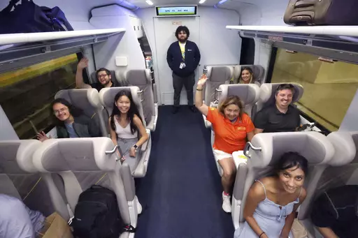 Passengers celebrate as the first Brightline train to Miami for the debut of service from Orlando International Airport pulls out of the station, early Friday, Sept. 22, 2023. The high-speed Orlando-Miami route marks first new privately-owned inter-city passenger service to roll out in the U.S. in 100 years. (Joe Burbank /Orlando Sentinel via AP)