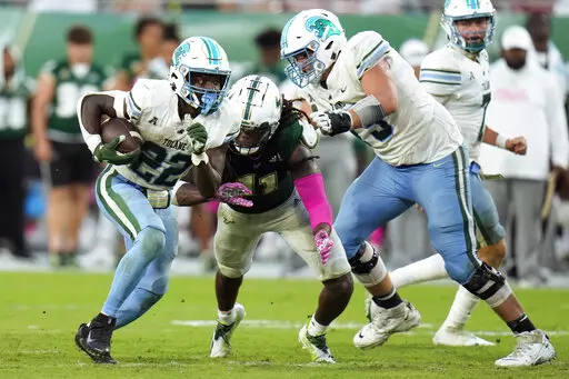 Tulane running back Tyjae Spears (22) heads upfield as offensive lineman Joey Claybrook (79) puts a block on South Florida linebacker Dwayne Boyles (11) during the second half of an NCAA college football game Saturday, Oct. 15, 2022, in Tampa, Fla. (AP Photo/Chris O'Meara)