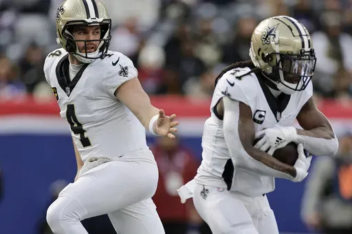 New Orleans Saints quarterback Derek Carr (4) hands off the ball to running back Alvin Kamara (41) during the first quarter of an NFL football game against the New York Giants, Sunday, Dec. 8, 2024, in East Rutherford, N.J. (AP Photo/Adam Hunger)
