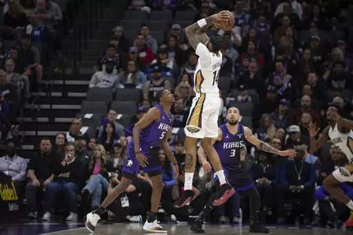 New Orleans Pelicans forward Brandon Ingram (14) shoots over Sacramento Kings guards De'Aaron Fox (5) and Chris Duarte (3) in the first quarter of an NBA basketball game in Sacramento, Calif., Sunday, Jan. 7, 2024. (AP Photo/José Luis Villegas)
