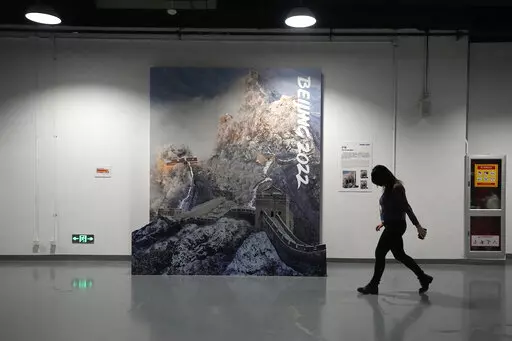 A person walks past a display of the Great Wall of China in a lower level of the Main Media Center ahead of the 2022 Winter Olympics, Jan. 30, 2022, in Beijing. (AP Photo/Jeff Roberson, File)