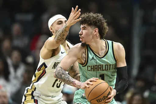 Charlotte Hornets guard LaMelo Ball (1) is defended by New Orleans Pelicans guard Jose Alvarado (15) during the first half of an NBA basketball game, Saturday, Jan. 25, 2025, in Charlotte, N.C. (AP Photo/Matt Kelley)