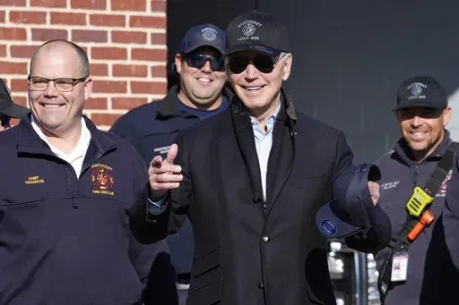President Joe Biden, center, standing next to Nantucket Fire Department Chief Michael Cranson, left, talks during a visit with firefighters on Thanksgiving Day at the Nantucket Fire Department in Nantucket, Mass., Thursday, Nov. 24, 2022. (AP Photo/Susan Walsh)