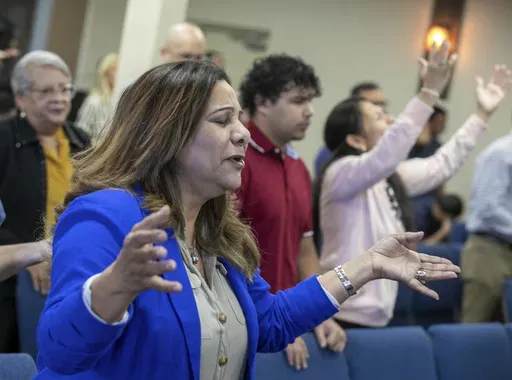 Fatima Guzman prays during a church service at the Centro Cristiano El Pan de Vida, a mid-size Church of God of Prophecy congregation in Kissimmee, Florida, Sunday, Feb. 2, 2025. (AP Photo/Alan Youngblood)