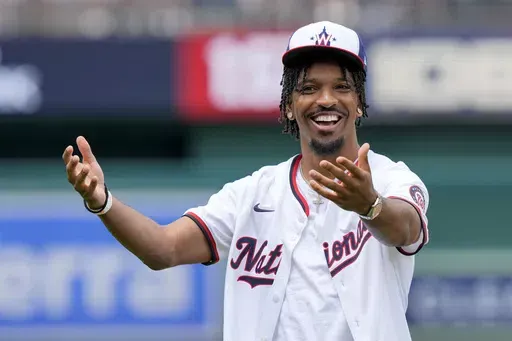 Washington Commanders quarterback Jayden Daniels reacts after throwing out a ceremonial first pitch before a baseball game between the Washington Nationals and the Atlanta Braves at Nationals Park, Sunday, June 9, 2024, in Washington. (AP Photo/Alex Brandon)