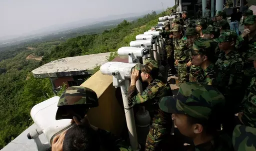 South Korean soldiers look at the North Korean side through binoculars at Dora Observation Post in the demilitarized zone, DMZ, near the border village of Panmunjom that separates the two Koreas since the Korean War, in Paju, north of Seoul, South Korea, Wednesday, May 27, 2009. A series of low-slung buildings and somber soldiers dot the landscape of the DMZ, the swath of land between North and South Korea where a soldier on a tour crossed into North Korea on Tuesday, July 18, 2023, under circum