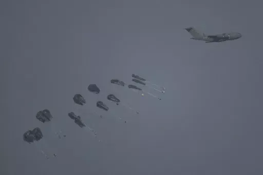 An aircraft airdrops humanitarian aid over northern Gaza Strip as seen from southern Israel, Thursday, March 28, 2024. (AP Photo/Leo Correa)