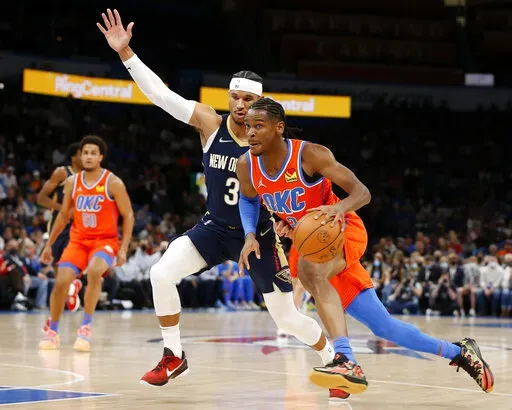 Oklahoma City Thunder guard Shai Gilgeous-Alexander (2) goes against New Orleans Pelicans guard Josh Hart (3) during the first half of an NBA basketball game, Sunday, Dec. 26, 2021, in Oklahoma City. (AP Photo/Garett Fisbeck)