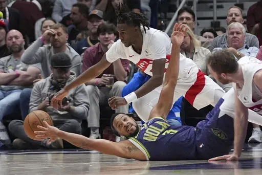 New Orleans Pelicans guard CJ McCollum (3) falls for a loose ball against Toronto Raptors guard Ja'Kobe Walter in the first half of an NBA basketball game in New Orleans, Wednesday, Nov. 27, 2024. (AP Photo/Gerald Herbert)