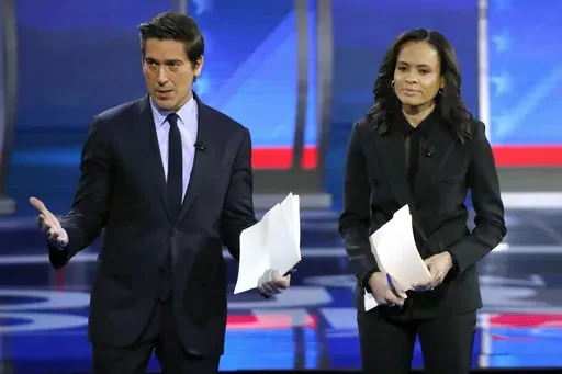 ABC World News Tonight Anchor David Muir, left, addresses members of the audience while standing with ABC News Live Anchor Linsey Davis, Friday, Feb. 7, 2020 in Manchester, N.H. (AP Photo/Elise Amendola, File)