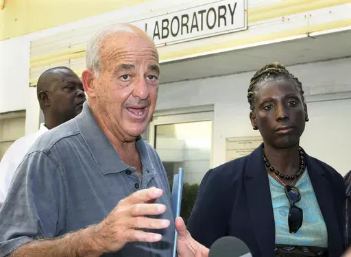 Pathologist Dr. Cyril Wecht, center, talks to the media while Bahamas' head coroner Linda Virgil, right, and attorney Michael Scott, left, listen outside the Rand Laboratory morgue at the Princess Margaret Hospital in Nassau, Bahamas, Sept. 17, 2006. Wecht, a pathologist and attorney whose biting cynicism and controversial positions on high-profile deaths such as President John F. Kennedy’s 1963 assassination caught the attention of prosecutors and TV viewers alike, died Monday, May 13, 2024. 