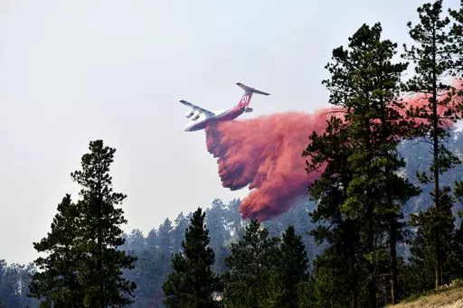 An aircraft drops fire retardant to slow the spread of the Richard Spring fire, east of Lame Deer, Mont., on Aug. 11, 2021. A legal dispute in Montana could drastically curb the government’s use of aerial fire retardant to combat wildfires. Environmentalists have sued the U.S. Forest Service over waterways being polluted with the potentially toxic red slurry that’s dropped from aircraft. Forest Service officials have acknowledged more than 200 cases of retardant landing in water. (AP Photo/M